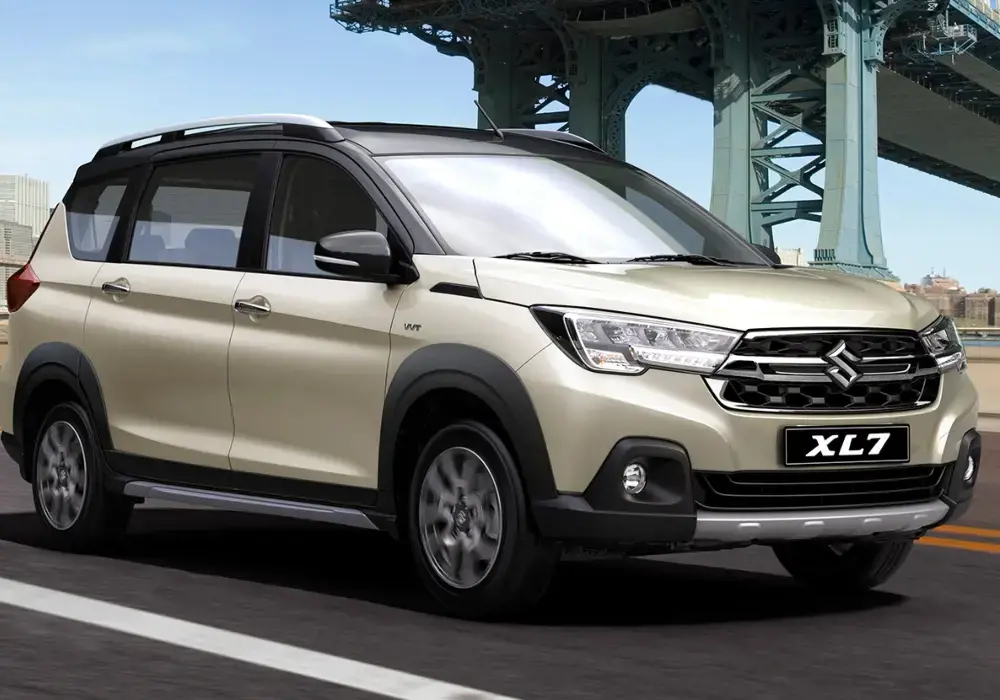 Suzuki XL7 de color claro conduciendo por una carretera.