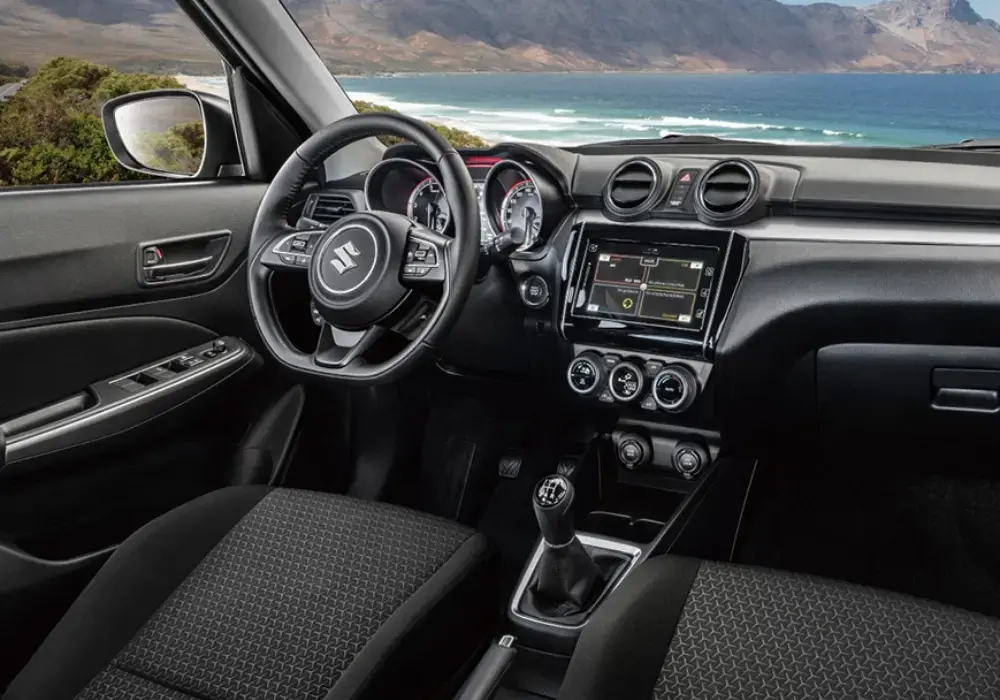 Interior del Suzuki Swift: volante, panel de instrumentos y palanca de cambios mecánica.